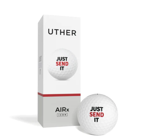 En vit golfboll med texten 'JUST SEND IT' framför en vertikal vit förpackning märkt 'UTHER' och 'AIRx [ICON]' med en röd linje, som också visar samma slogan på sidan av lådan.