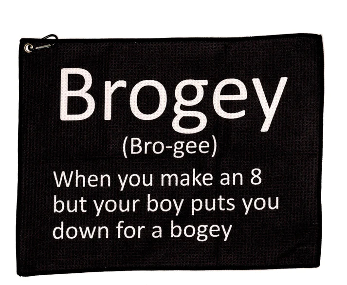 Svart golfhandduk med texten 'Brogey (Bro-gee) When you make an 8 but your boy puts you down for a bogey' i vit typsnitt, en humoristisk term som används inom golf.